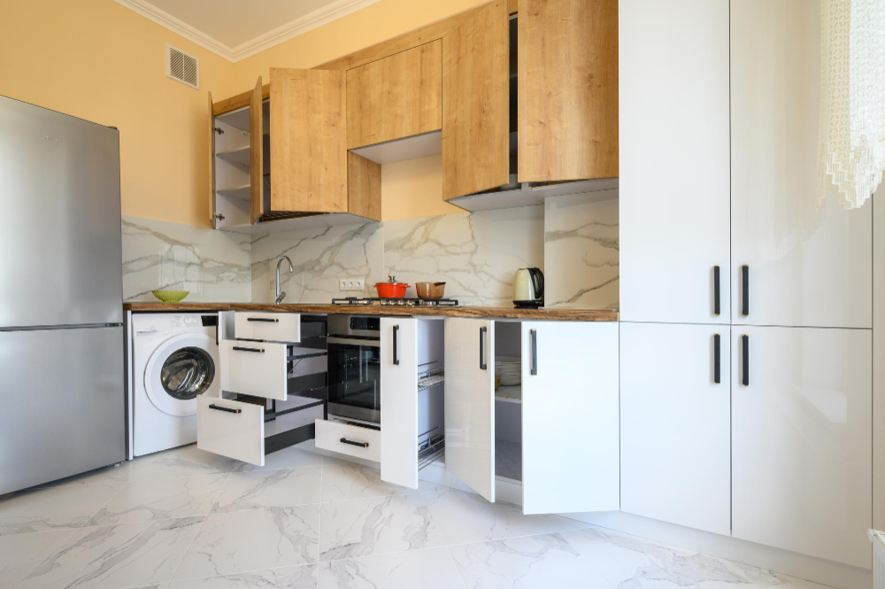 Kitchen with open cabinet doors and pull-out storage beside appliances